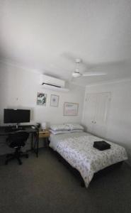 a bedroom with a bed and a desk with a computer at Terrace River House in Caddys Island