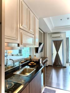 a kitchen with a sink and a bed in the background at Panbil Residence Apartment Lvl 15 with Forest View in Kangboi +19 photos
