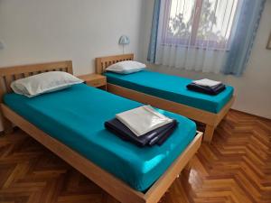 2 Betten in einem Zimmer mit blauer Bettwäsche in der Unterkunft Gumla House in Stara Novalja + 66 Fotos