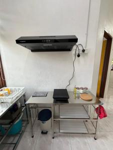 a kitchen counter with a hood over a stove at Santai DPermai Homestay in Selama