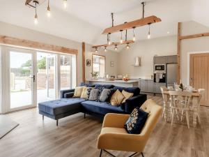 Una sala de estar con un sofá azul y una cocina. en Dip Tub Den - Uk35989, en Wansford 23 fotos más