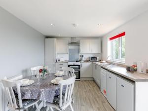 a kitchen with a table and chairs in a kitchen at Hill Crest Lodge 2 in Hemswell