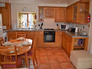 a kitchen with wooden cabinets and a wooden table at Nu-Holme in Windermere