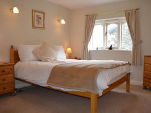 a bedroom with a large bed and a window at Nu-Holme in Windermere