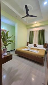 Un dormitorio con una cama con ventilador de techo. en Sai Pratham Nx, en Shirdi