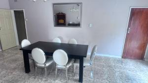 - une table à manger avec des chaises et un miroir dans l'établissement SVI Suits, à Bloemfontein