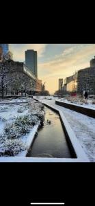 een rivier in een stad bedekt met sneeuw bij Suite vue sur la Tour Eiffel in Courbevoie