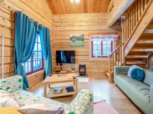 a living room with a couch and a tv in a cabin at Ty Afal - Uk42099 in Carno