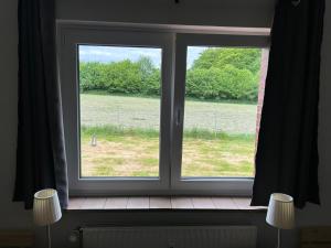 a window with a view of a field at Monteurzimmer - zwischen Hamburg & Lübeck in Todendorf