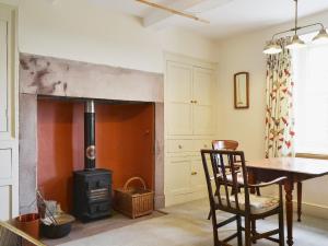 sala de estar con estufa de leña y mesa en High Birch Close, en Penruddock