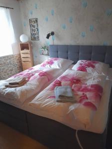 a bed with two blankets and a book on it at Ferienwohnung Monika Staßfurt OT Üllnitz an der A14 in Glöthe