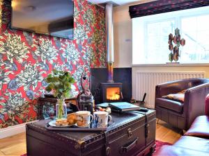 a living room with a coffee table with a fireplace at Annie Oswalds Cottage in Lucker