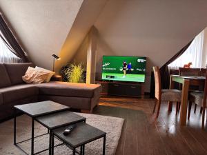 een woonkamer met een bank, een tv en een tafel bij Apartment Horec Donovaly in Donovaly