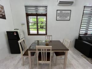 a dining room with a table and chairs at Santai DPermai Homestay in Selama
