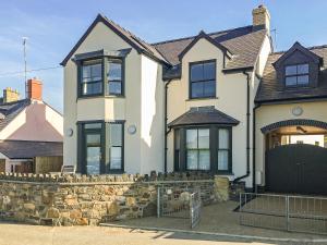 una gran casa blanca con un muro de piedra en Parrog Point, en Newport