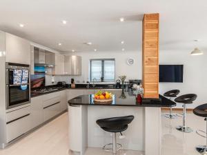 una cocina con una gran isla con taburetes negros en Parrog Point, en Newport