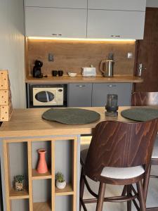 a kitchen with a counter with a table and chairs at Cozy studio near the park with huge verandah. in Veliko Tŭrnovo