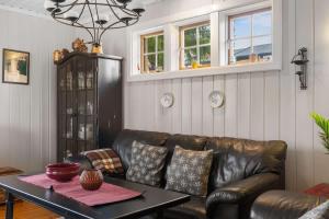 ein Wohnzimmer mit einer Ledercouch und einem Tisch in der Unterkunft Fagerasen 209 by Vacation Trysil in Trysil
