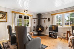 ein Wohnzimmer mit Kamin und Fernseher in der Unterkunft Fagerasen 209 by Vacation Trysil in Trysil + 13 Fotos