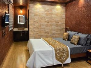 VālāvalにあるWalawal Bliss Farm Stayのベッドとレンガの壁がある寝室