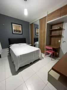 een slaapkamer met een bed, een bureau en een roze stoel bij Opportunity, COP30, Excellent Location! in Belém +6 foto's