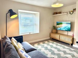 Una televisión o centro de entretenimiento en Palms 2 - Central, 5 mins walk to beach + parking!