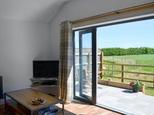a living room with a large sliding glass door at Harry's Den in Chapel Saint Leonards