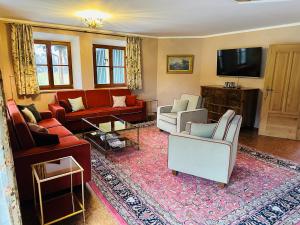 a living room with couches and a flat screen tv at VILLA SEEBERG - by "Schloss Gessenberg" luxurious vacation home with lake and mountain views, suitable for families and friends in Petting