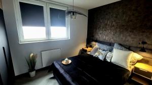 une chambre avec un lit noir et une fenêtre dans l'établissement Apartamenty Graniczna 1, à Rzeszów