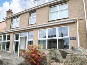 a building with white windows on the side of it at Llywnfor in Morfa Nefyn