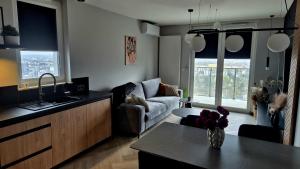 une cuisine et un salon avec un canapé et une table dans l'établissement Apartamenty Graniczna 1, à Rzeszów 13 autres photos
