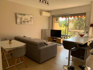 una sala de estar con un sofá y una mesa en Agréable 2 pièces à 150 m de la mer, en Cagnes-sur-Mer