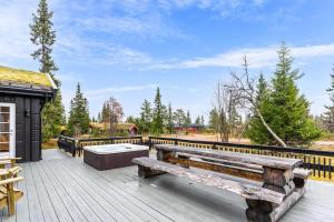 a wooden deck with a bench and a hot tub at Fagerasen 303 by Vacation Trysil in Mælem