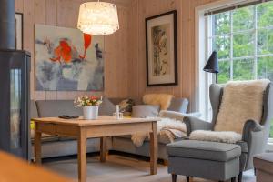 a living room with a table and chairs and a couch at Fagerasen 303 by Vacation Trysil in Mælem +25 photos