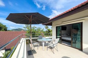 a patio with a table and chairs and an umbrella at Charming 3BR villa with Private pool in Bangrak Beach