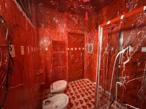 a red bathroom with two toilets and a shower at Paciu Maison in Ozzano dell Emilia