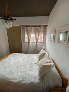 Un dormitorio con una cama blanca y una ventana. en El lugar soñado, en Mar del Plata