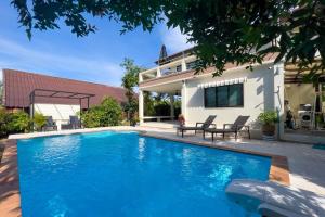 a swimming pool in front of a house at Charming 3BR villa with Private pool in Bangrak Beach