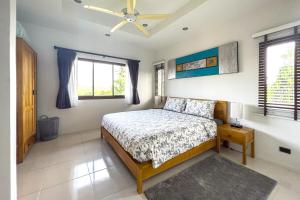 a bedroom with a bed and a ceiling fan at Charming 3BR villa with Private pool in Bangrak Beach