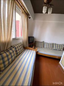 Una sala de estar con dos camas y una ventana. en El lugar soñado, en Mar del Plata