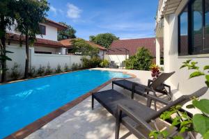 a swimming pool with a bench and a house at Charming 3BR villa with Private pool in Bangrak Beach +15 photos