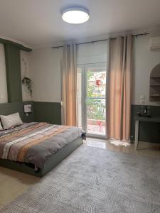 a bedroom with a bed and a large window at Bloem in Komotini