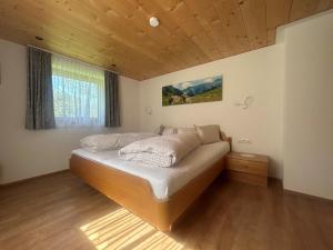 een slaapkamer met een groot bed met een houten plafond bij Haus Lechner in Gaschurn