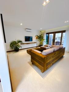 a large living room with a large wooden couch at Hura Vilas in Itarema