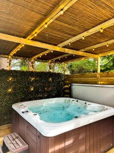a jacuzzi tub sitting under a wooden roof at Arawn 4 - Hot Tub - Dog friendly - Family in Almondbank