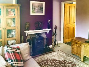 a living room with a fireplace and purple walls at New House Farm Annexe in Neenton