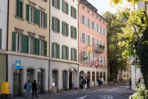 a street in a city with buildings with green shutters at Hotel R5 Budget - Chur in Chur