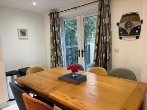 ein Esstisch mit einer Vase mit Blumen darauf in der Unterkunft Rosemarinus a Peaceful 4Bed 3Bath Townhouse Ballycastle in Ballycastle