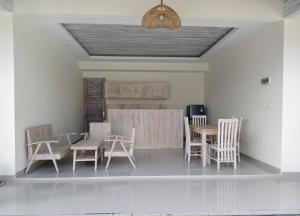 a dining room with wooden tables and chairs at Villa kembar ungasan in Ungasan