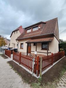 a house with a wooden fence in front of it at Ferienhaus An der Brunnenaue in Stralsund